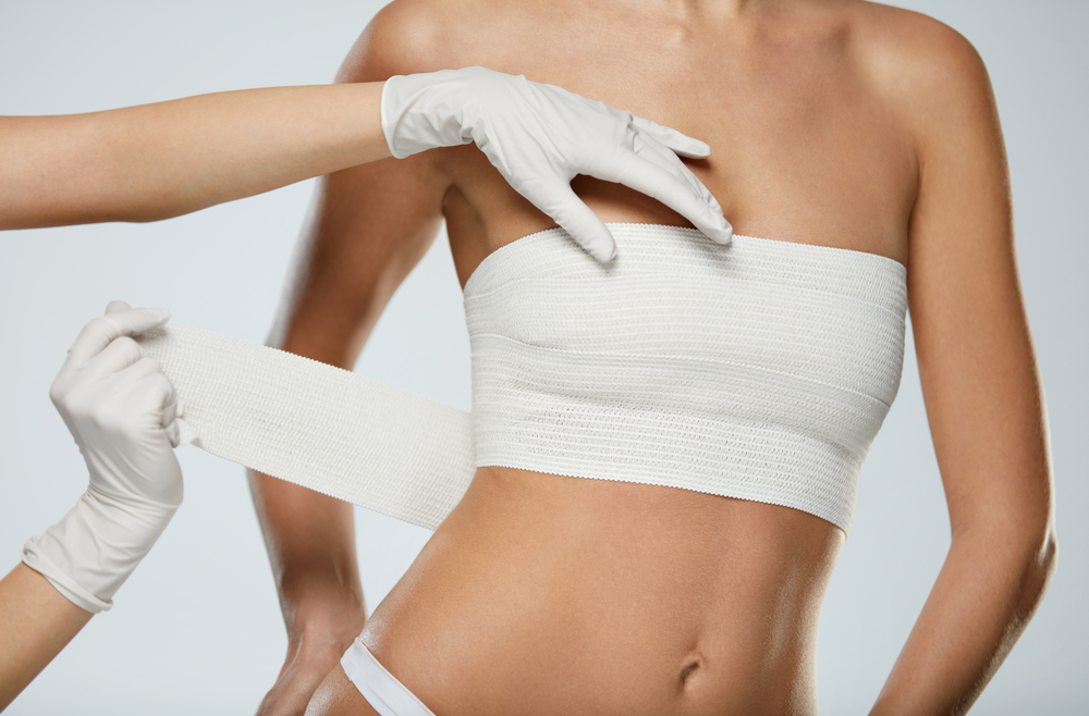 Woman with bandage across her chest after breast reconstruction.